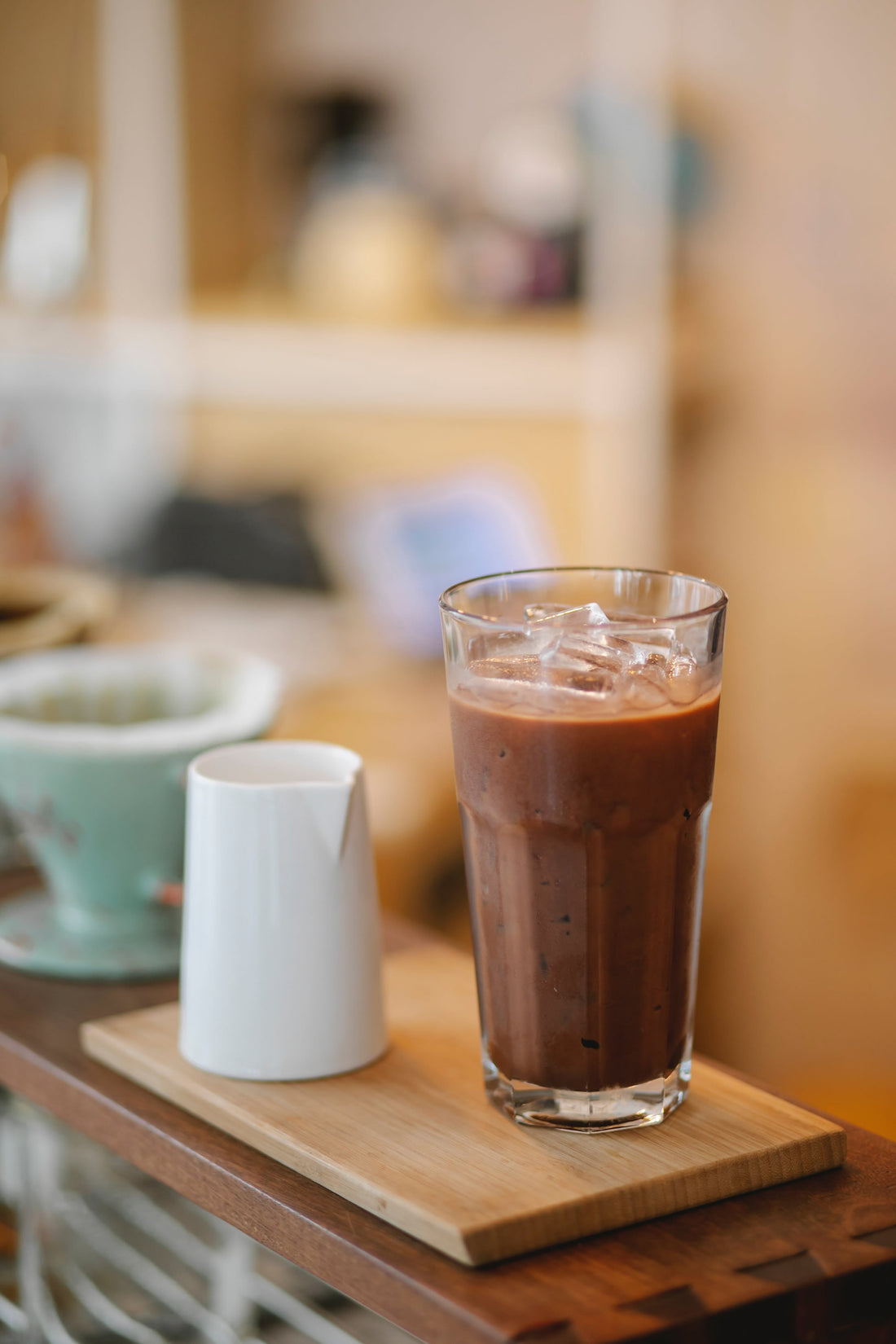 A glass of iced coffee latte on a kitchen island.