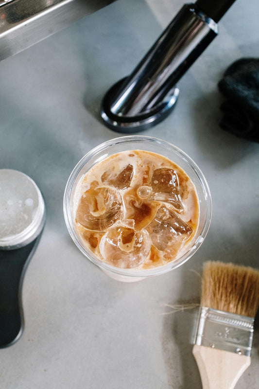 Iced latte in a transparent container and this is for the post how to make an iced latte